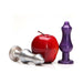 Two silicone butt plugs in metallic silver and purple colors displayed next to a red apple for size comparison.
