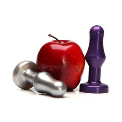 Two metallic and purple tulip-shaped butt plugs displayed next to a red apple on a white background.