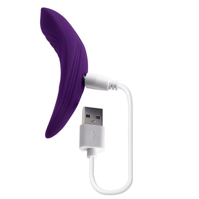 Purple curved silicone wearable vibrator with attached white USB charging cable on white background.