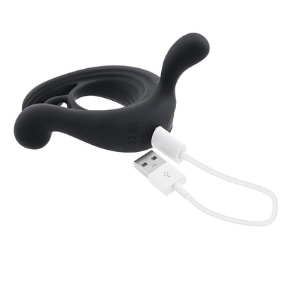 Black silicone vibrating cock ring with remote control and USB charging cable on white background.