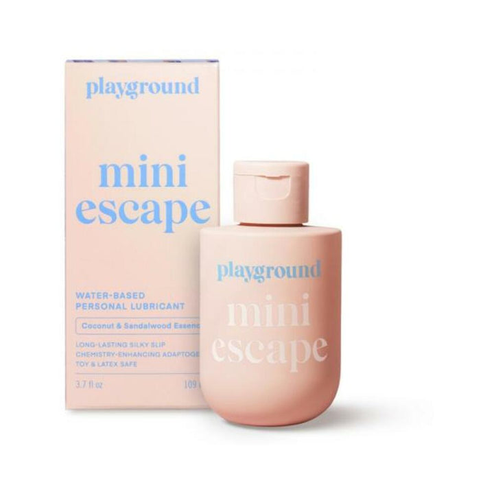 Playground Mini Escape water-based personal lubricant bottle and box in soft pink with blue text, coconut and sandalwood essence.