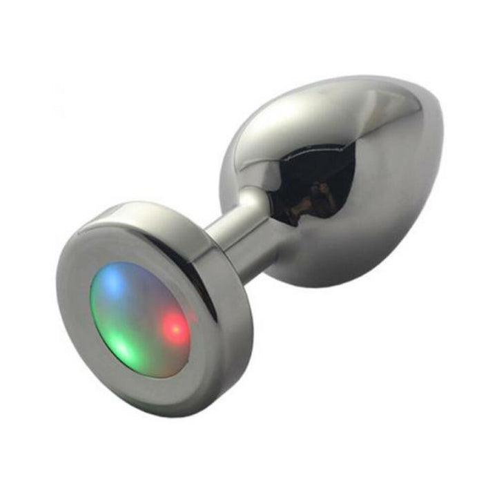 Small metal anal plug with smooth finish and LED light-up base showing red, green, and blue colors.