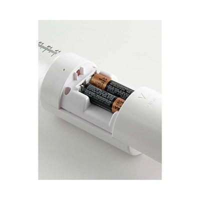 Close-up of the Pump Worx Mega Vac Power Pump battery compartment showing two AA batteries installed in the white device.