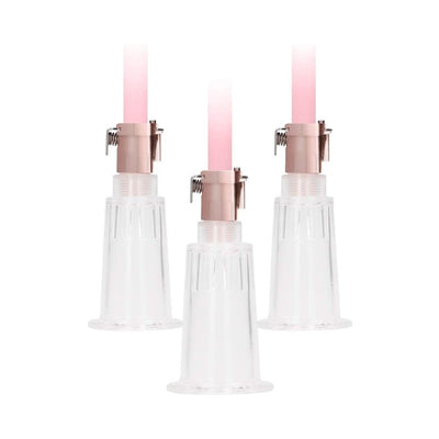 Medium-sized clear silicone pump cups with rose gold connectors and pink tubing for clitoral and nipple stimulation.