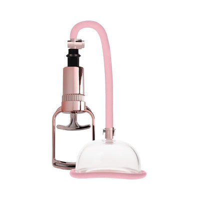 Pumped penis extender with rose gold hand pump and clear silicone suction cup connected by a pink flexible tube.