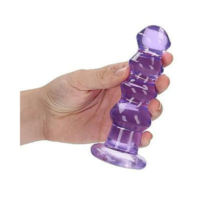 Hand holding a purple crystal clear curvy 5.5 inch dildo with suction base for hands-free use.