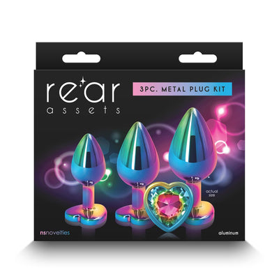Rear Assets 3-piece metal plug kit with rainbow chrome finish and heart-shaped jeweled base, displayed in packaging.