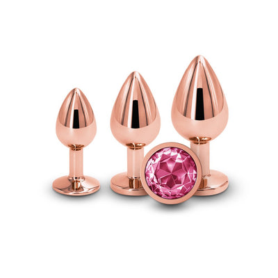 Three rose gold graduated metal plugs with a pink gem base displayed on a white background.