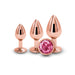 Three rose gold graduated metal plugs with a pink gem base displayed on a white background.