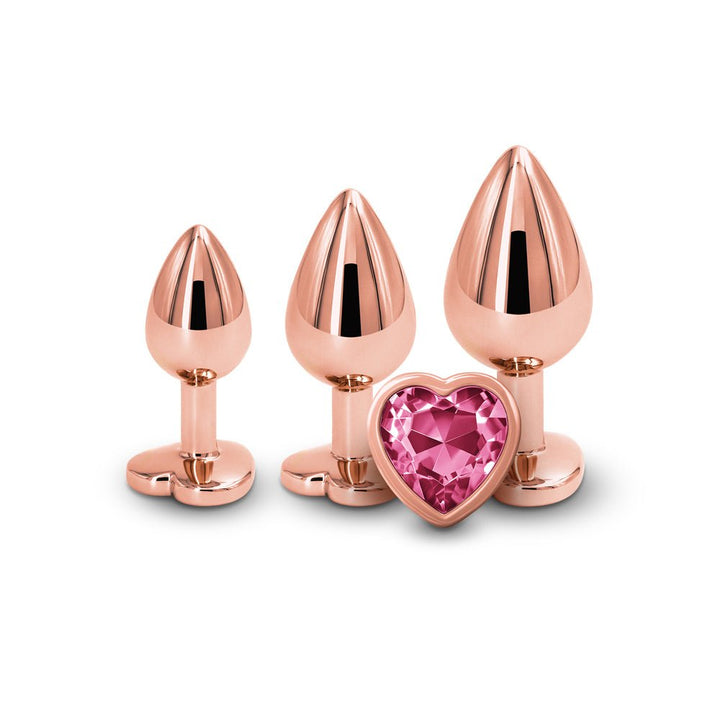 Three rose gold graduated metal plugs with a pink heart-shaped gem on the base, displayed on a white background.