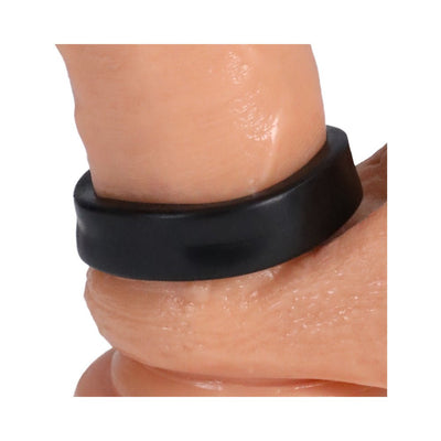Close-up of a black flexible ring worn around the base of a finger, showcasing its snug fit and smooth texture.