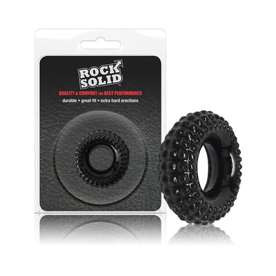 Black textured stretchy ring with raised ridges displayed next to its Rock Solid branded clamshell packaging.