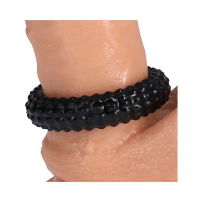 Black textured stretchy ring worn on a finger, showcasing its flexible and ridged design.