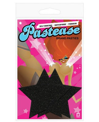 Black glitter star-shaped pasties on colorful Pastease branded packaging with illustrated woman background.