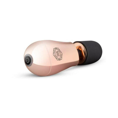 Compact rosy gold mini massager with soft black silicone head and single button control, USB rechargeable and travel-ready.