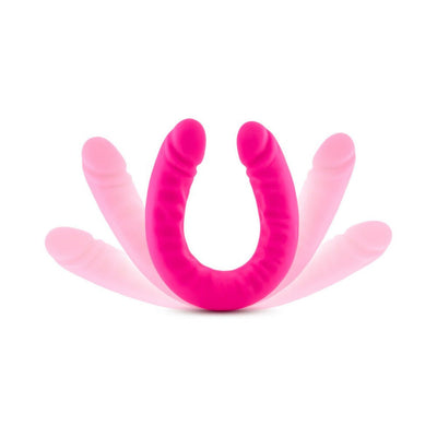 Flexible double-ended silicone dildo in vibrant hot pink with realistic texture and slim design on white background.