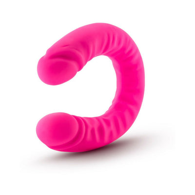 Bright pink silicone double-ended dildo with slim, textured design and realistic detailing on both ends.
