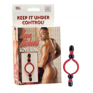 Sean Michaels Love Ring adjustable red cock ring with black beads shown next to product packaging featuring a shirtless man.
