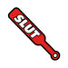 Red enamel lapel pin shaped like a paddle with the word "SLUT" in bold white letters.