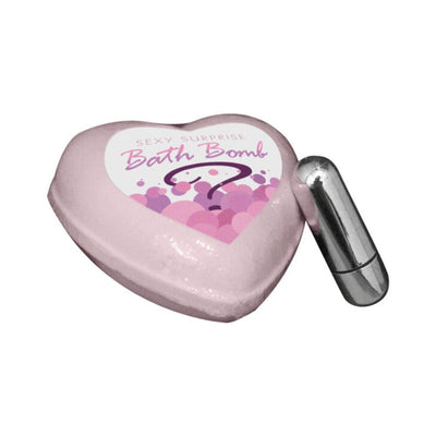 Heart-shaped pink bath bomb labeled Sexy Surprise with a small silver bullet vibrator beside it.