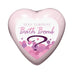 Heart-shaped pink bath bomb with a label reading Sexy Surprise Bath Bomb and decorative pink bubbles.