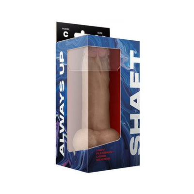 Shaft Model C liquid silicone dildo with balls in pine color, displayed in blue and black packaging with clear window.