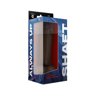 Shaft Model C liquid silicone dildo with balls in mahogany color displayed in blue and red packaging with clear window.