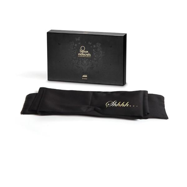 Black satin blindfold with "Shhhh" text in gold script, displayed with elegant black Bijoux Indiscrets packaging box.