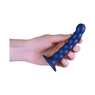 Hand holding a metallic blue beaded silicone G-spot dildo with a suction cup base.