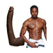 Chocolate-colored realistic dildo with suction cup next to a shirtless muscular man in silver shorts.