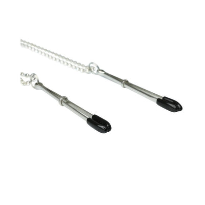 Close-up of silver-toned nipple clips with black rubber tips on a delicate chain accessory.