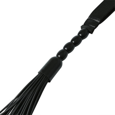 Close-up of black faux leather flogger with smooth wooden beads on the handle and multiple thin tails.
