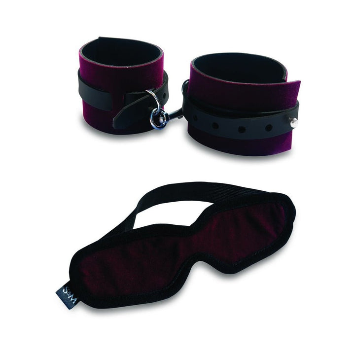 Velvet purple and black adjustable handcuffs paired with a matching soft blindfold with elastic strap.
