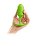Hand holding a bright green weighted silicone plug with a flexible neck and curved base.