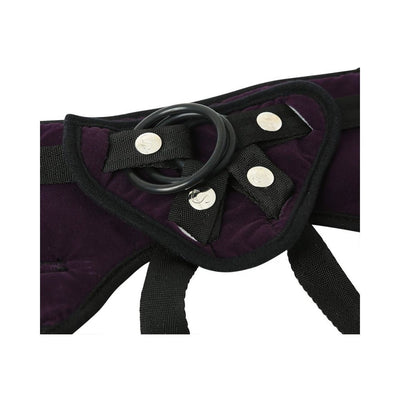 Close-up of purple plush strap-on harness with black adjustable straps and interchangeable rubber O-ring.