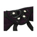 Close-up of purple plush strap-on harness with black adjustable straps and interchangeable rubber O-ring.