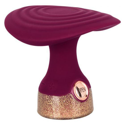 Compact handheld massager with flexible ridged head in deep purple and glittery gold base with touch controls.