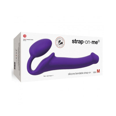 Purple silicone bendable strap-on in medium size displayed on white packaging box with branding and award logo.