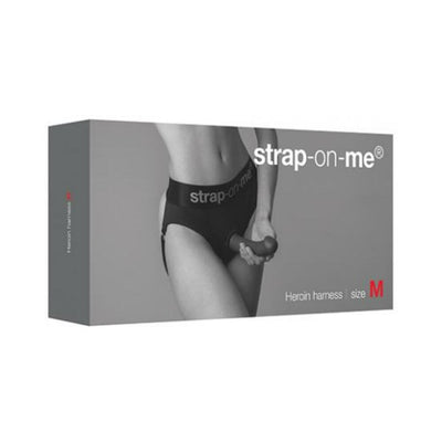 Packaging box for Strap-on-me Harness Lingerie Heroine in size M featuring a model wearing the black harness.