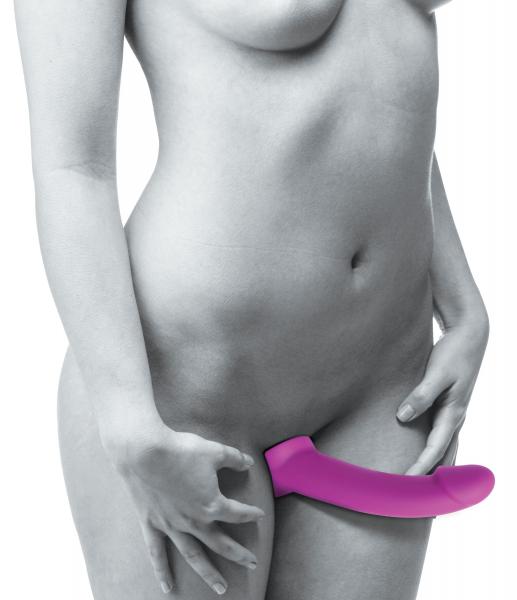 Woman demonstrating use of a pink strapless silicone vibrating dildo designed for hands-free pleasure and G-spot stimulation.