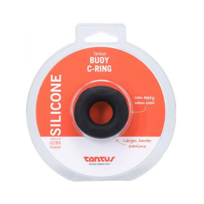 Small black silicone Tantus Buoy C-ring in clear and orange retail packaging with product details.