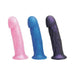 Three translucent silicone Goliath dildos in pink, blue, and midnight purple with realistic texture and suction bases.