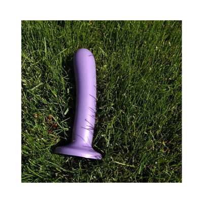 Purple Tantus Silk Large dildo resting on green grass background.