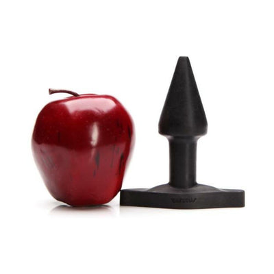 Black tapered Tantus Stud Plug displayed next to a red apple for size comparison on a white background.