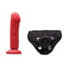 Crimson red realistic dildo with textured surface and black adjustable strap-on harness with metal snaps and O-ring.