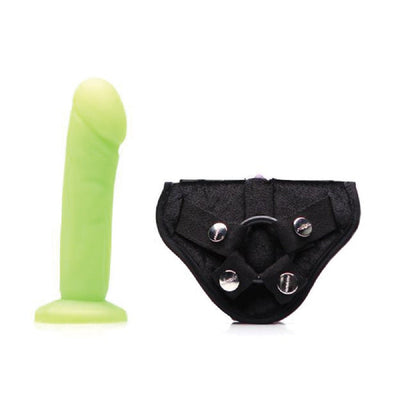 Lime green realistic dildo with detailed texture and black adjustable velvet strap-on harness with metal snaps.