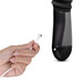 Hand holding USB magnetic charging cable near the black Temptasia Lazarus thrusting dildo handle.