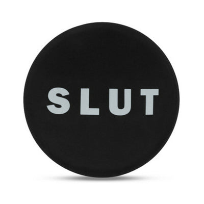 Black silicone butt plug with a round base featuring the word SLUT in bold white letters.