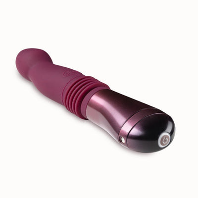 Temptasia Trixie thrusting dildo in wine color with curved silicone shaft and metallic handle with power button.
