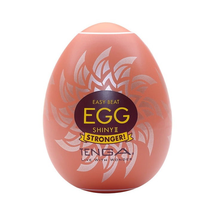 Tenga EGG Shiny II in orange egg-shaped casing with silver sunburst design and bold yellow text on front.